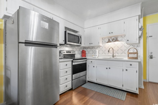 kitchen featuring stainless steel appliances, light countertops, a sink, and tasteful backsplash