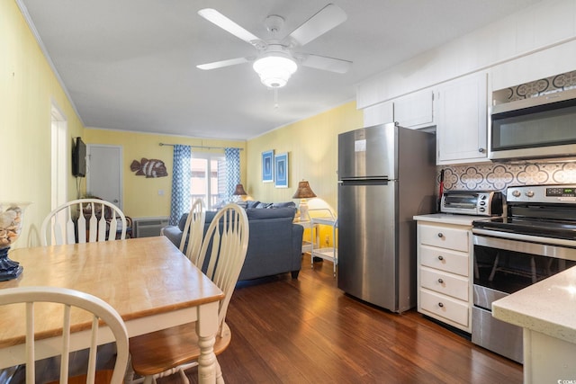dining space with ornamental molding, a ceiling fan, dark wood-style flooring, and a toaster