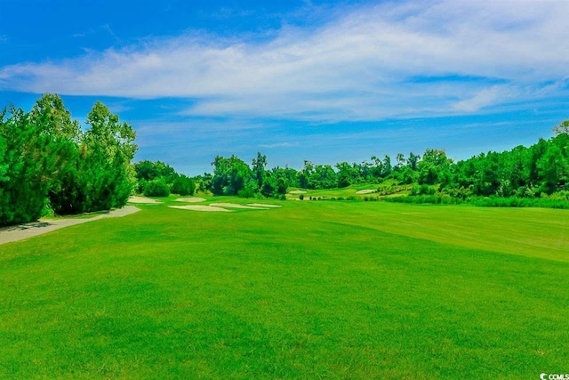 view of community with golf course view and a lawn