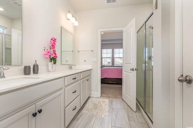 bathroom featuring a stall shower, marble finish floor, visible vents, a sink, and double vanity