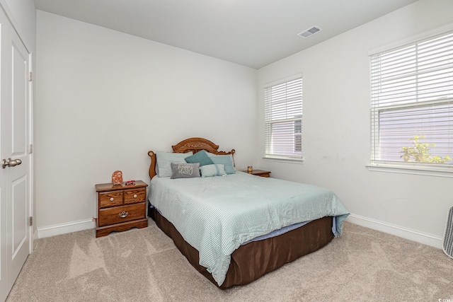 bedroom with carpet floors, baseboards, and visible vents