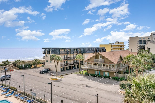 view of property featuring a water view and uncovered parking