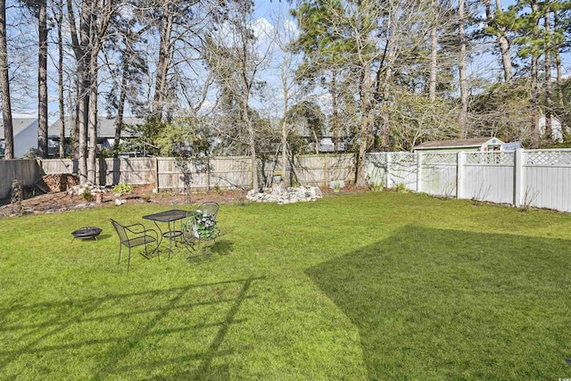 view of yard with a fenced backyard and an outdoor fire pit