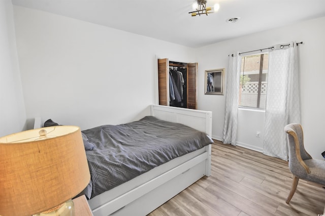 bedroom featuring visible vents, light wood-type flooring, and baseboards