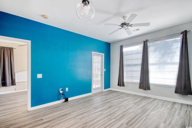 spare room with ceiling fan, baseboards, a healthy amount of sunlight, and wood finished floors