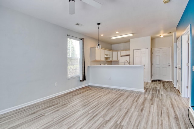 kitchen featuring visible vents, baseboards, light wood-style floors, and freestanding refrigerator