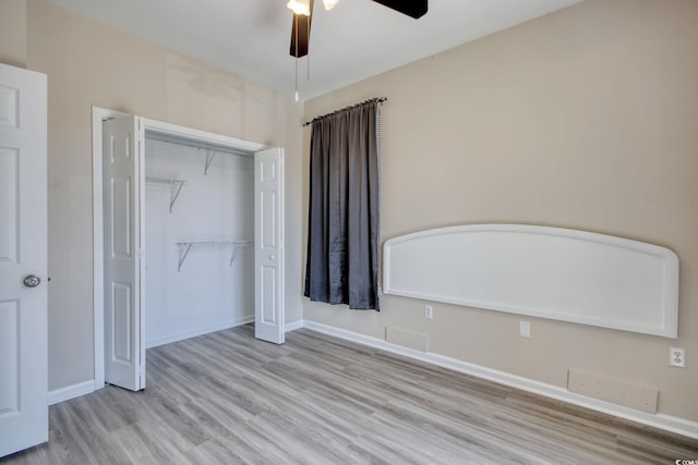 unfurnished bedroom with a ceiling fan, wood finished floors, a closet, and baseboards