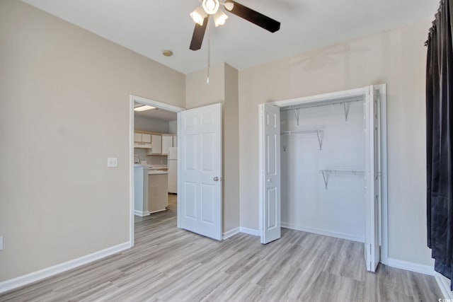 unfurnished bedroom featuring light wood finished floors, baseboards, and freestanding refrigerator