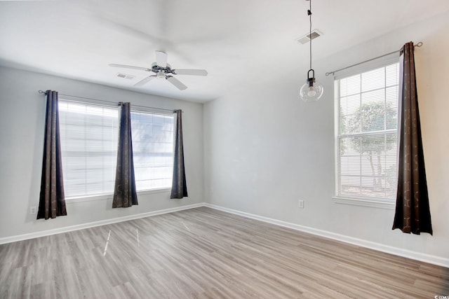spare room featuring visible vents, baseboards, and light wood-style floors