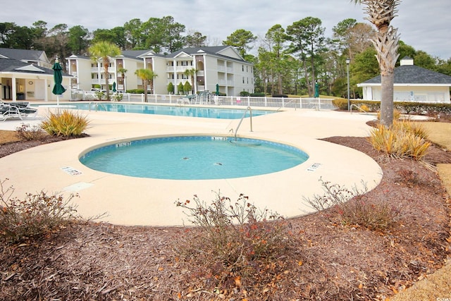 pool with a patio area and fence