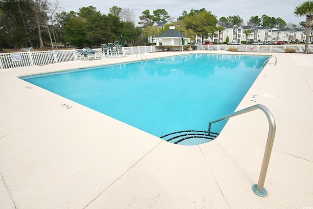 pool featuring a residential view, a patio, and fence