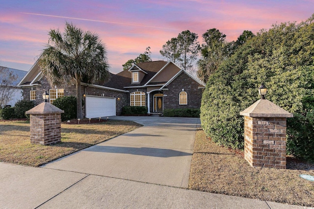 traditional-style home with brick siding, driveway, and a garage