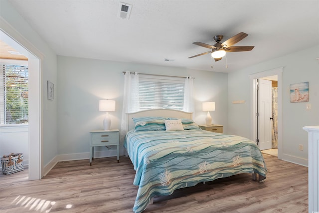 bedroom featuring visible vents, baseboards, light wood-style flooring, and a ceiling fan