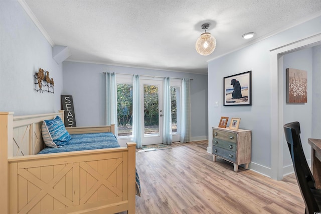 bedroom featuring crown molding, baseboards, wood finished floors, a textured ceiling, and access to outside