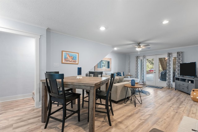 dining space featuring french doors, light wood-type flooring, baseboards, and crown molding