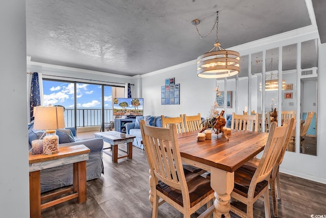 dining area with visible vents, a textured ceiling, wood finished floors, and ornamental molding