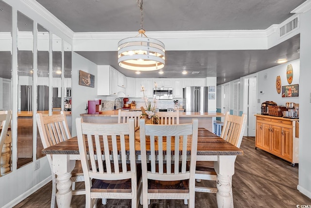 dining room featuring dark wood finished floors, visible vents, and ornamental molding