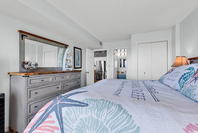 bedroom featuring connected bathroom, visible vents, freestanding refrigerator, and a textured ceiling