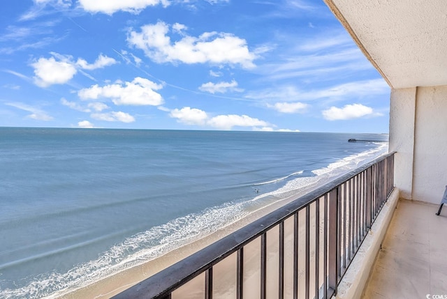 balcony featuring a water view and a beach view