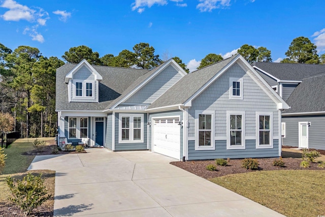 view of front of house with an attached garage, concrete driveway, a front yard, and a shingled roof