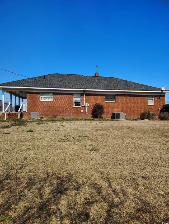 1375 Kenny Jordan Rd, Tabor City, NC 28463 - exterior space featuring a yard, brick siding, roof with shingles, and cooling unit