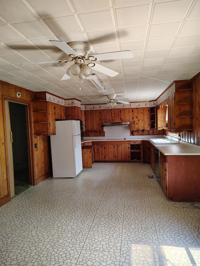 1375 Kenny Jordan Rd, Tabor City, NC 28463 - kitchen featuring brown cabinets, wooden walls, light floors, and freestanding refrigerator