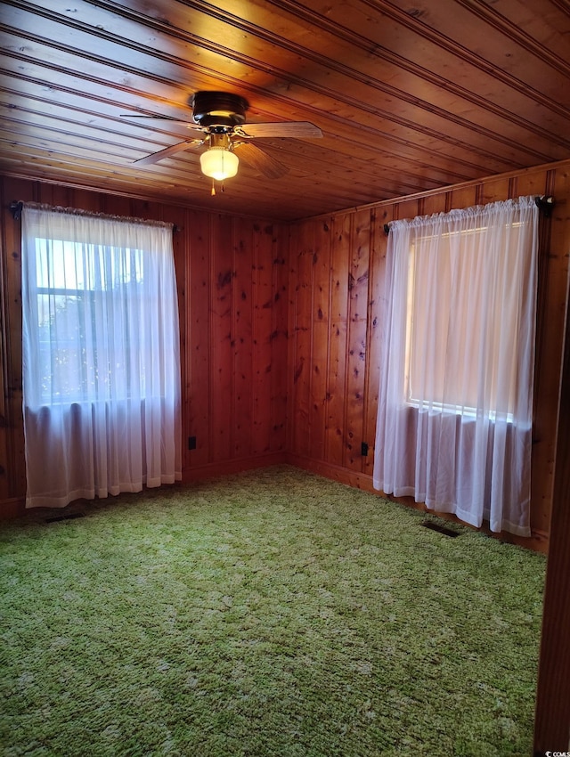 1375 Kenny Jordan Rd, Tabor City, NC 28463 - carpeted empty room featuring a ceiling fan, wood ceiling, visible vents, and wood walls