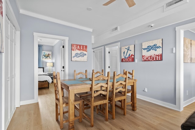 dining space with visible vents, ornamental molding, and light wood-style flooring