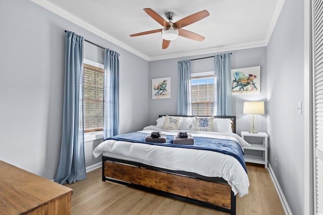 bedroom featuring baseboards, ornamental molding, and light wood finished floors