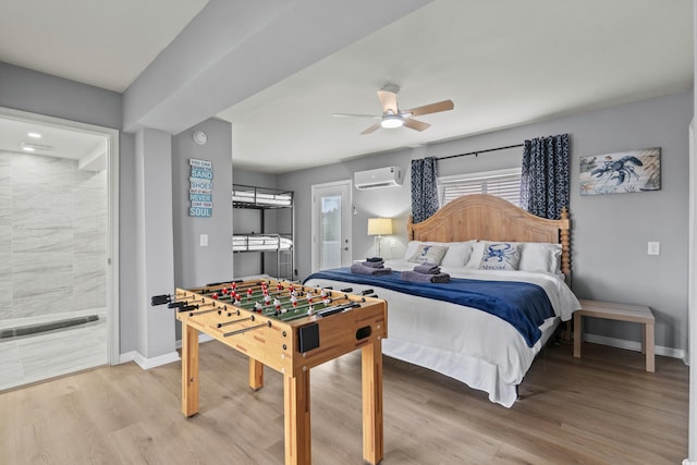 bedroom with light wood-style flooring, baseboards, and a wall mounted air conditioner