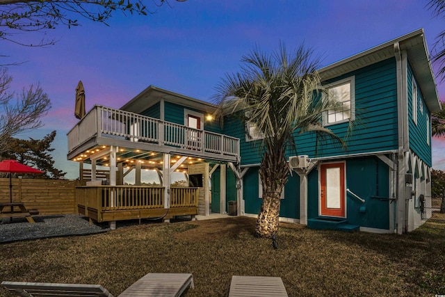 rear view of property featuring a wall mounted air conditioner, a wooden deck, and fence