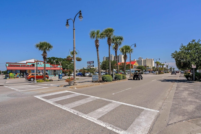 view of street with curbs, sidewalks, and street lighting