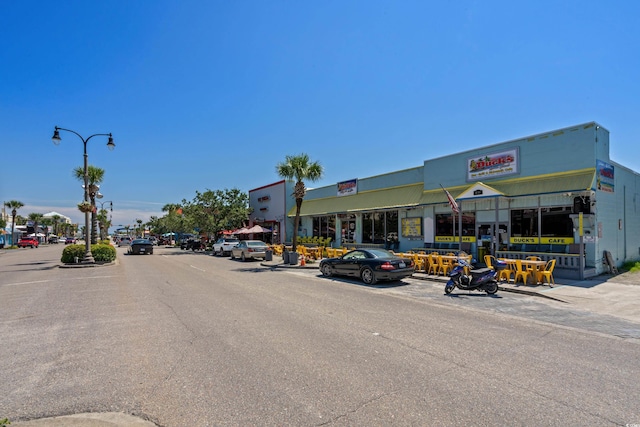 view of street featuring curbs, sidewalks, and street lighting