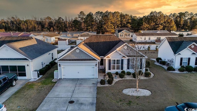 view of front of house featuring a garage, a residential view, a front yard, and driveway