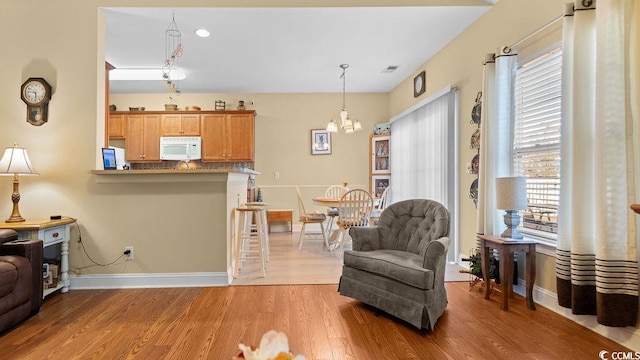 sitting room with visible vents, an inviting chandelier, baseboards, and light wood-style floors