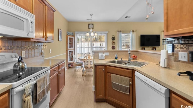 kitchen with light wood-style floors, white appliances, light countertops, and brown cabinets