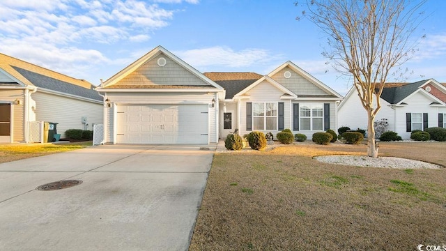 view of front of property featuring a front yard, a garage, and driveway