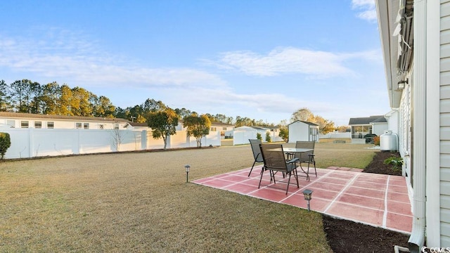 view of yard featuring a patio, an outdoor structure, and fence