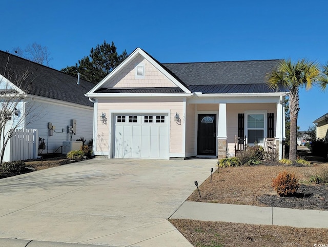 craftsman-style home with a standing seam roof, a porch, an attached garage, concrete driveway, and metal roof