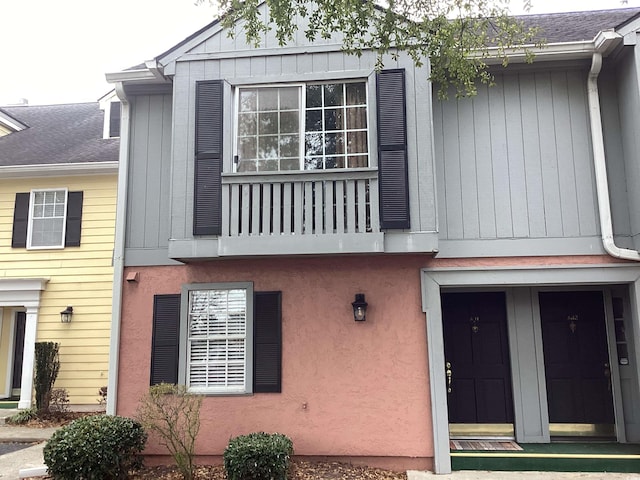 exterior space featuring a balcony and roof with shingles