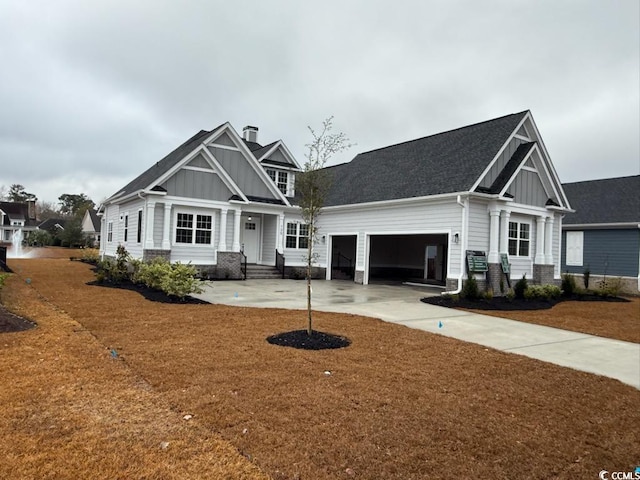 craftsman house with a front lawn, board and batten siding, concrete driveway, and an attached garage