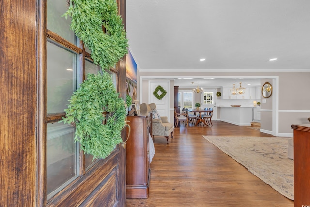 foyer entrance featuring recessed lighting, ornamental molding, an inviting chandelier, and wood finished floors