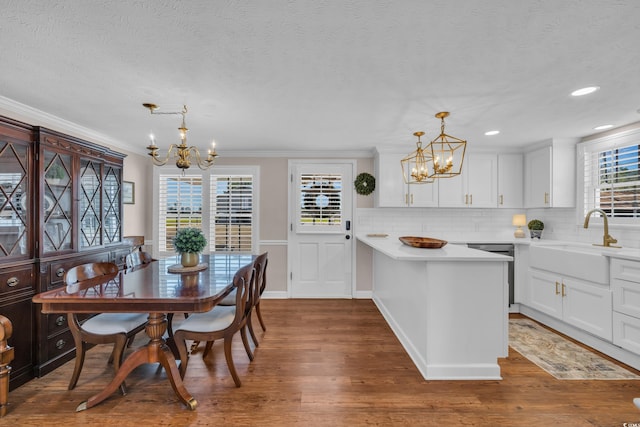 dining space featuring a chandelier, crown molding, a textured ceiling, and dark wood-type flooring