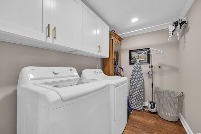 laundry area featuring baseboards, ornamental molding, washer and dryer, dark wood-style floors, and cabinet space