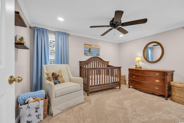 carpeted bedroom featuring recessed lighting, a ceiling fan, a nursery area, and crown molding