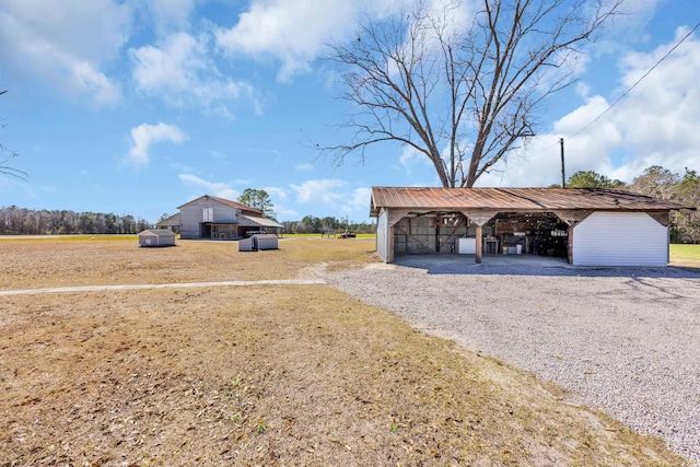 view of yard with an outdoor structure, a carport, and a pole building