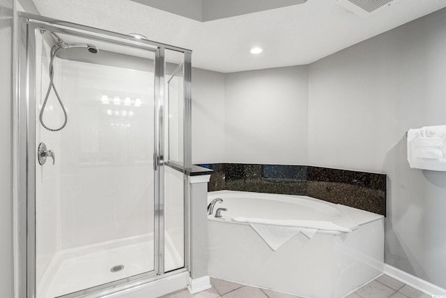 bathroom with a bath, visible vents, a shower stall, and baseboards