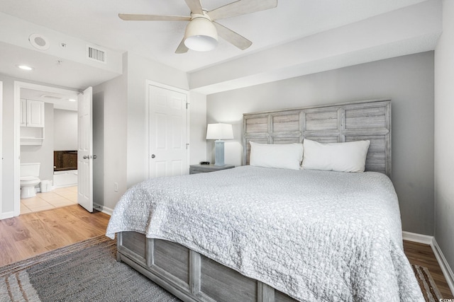 bedroom featuring visible vents, baseboards, wood finished floors, and a ceiling fan