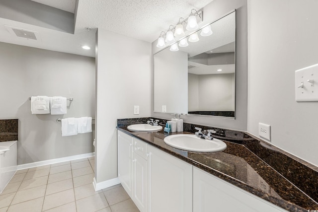 full bathroom featuring tile patterned flooring, a textured ceiling, baseboards, and a sink