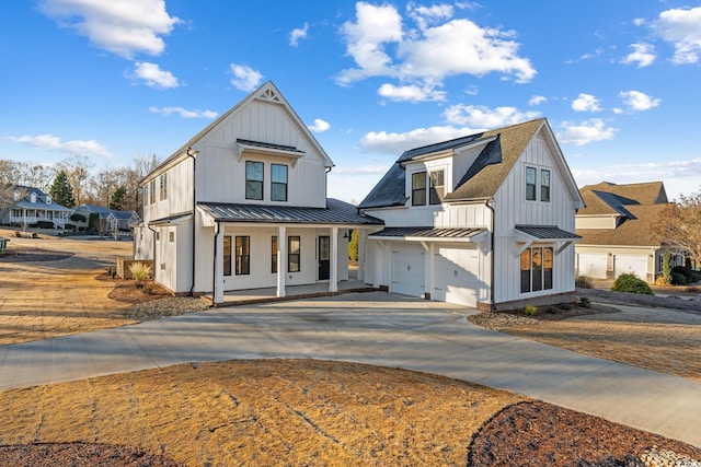 modern farmhouse style home featuring a garage, board and batten siding, and a standing seam roof